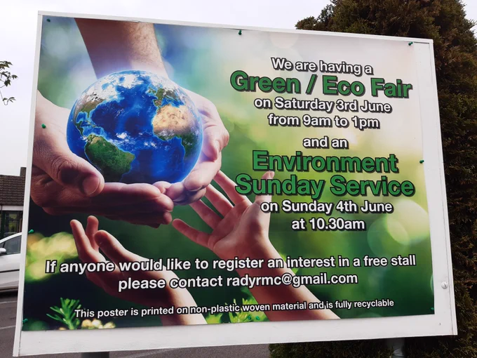 Exterior poster for Green / Eco Fair featuring large and small hands holding a small glowing globe.