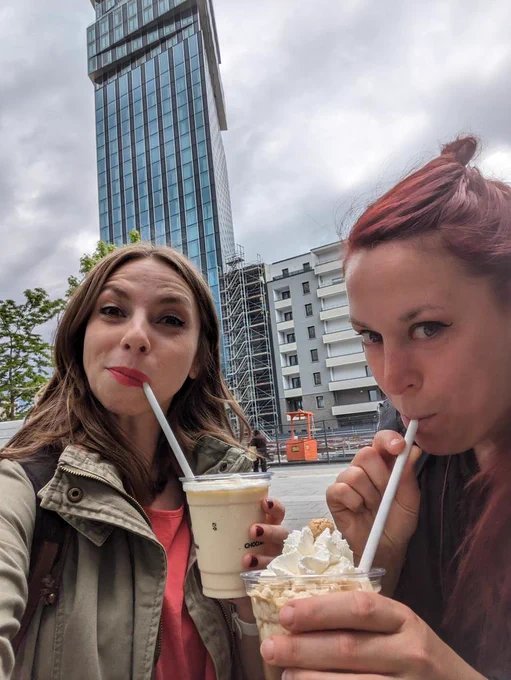 Veerle and me drinking milkshakes in front of a very tall building 