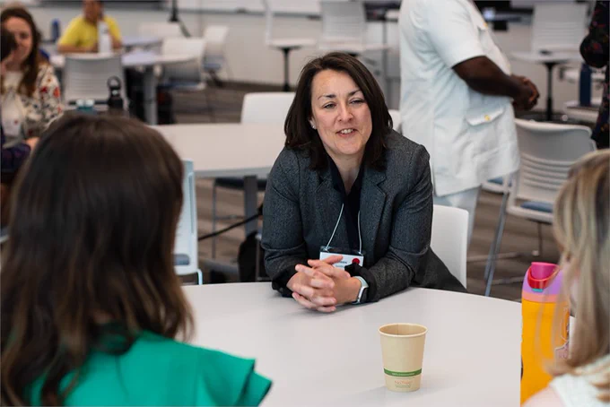 URI's Dr. Coleen Suckling, a forum attendee, speaks with two students across the table. Photo by Shaun Kirby