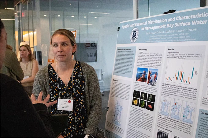 URI graduate student Sarah Davis stands in front of her poster presentation. Photo by Shaun Kirby
