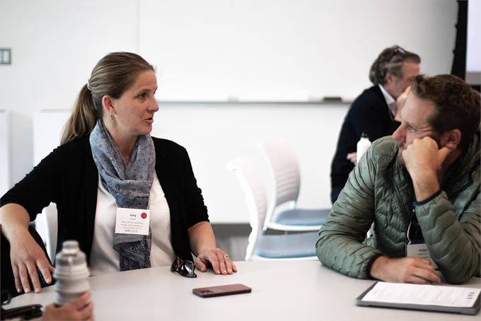 Roger Williams University's Dr. Koty Sharp (left), one of the panelists at the forum, speaks with a colleague. Photo by Shaun Kirby