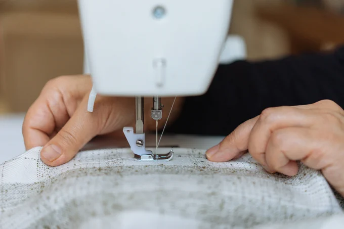 A close-up of a person using the sewing machine.