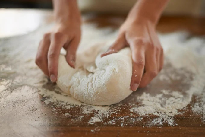 A close-up of a person working with dough.