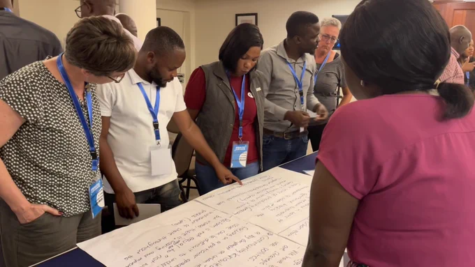 Researchers looking at working group notes around a table.