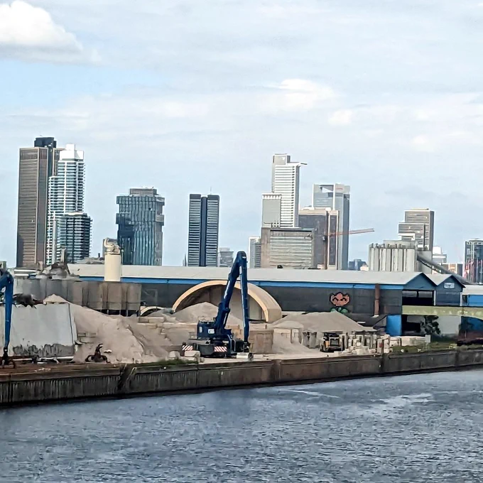 The skyline of Frankfurt as seen from a moving train, hence a bad photo! In the foreground, a glimpse of the river Main and a construction site
