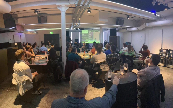 A view from the back of our event space, showing our audience of 50 people watching a presentation