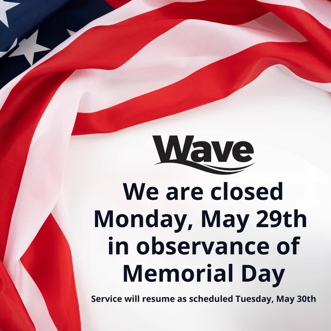 The United States flag sits behind a notice of service closure in honor of Memorial Day. "We are closed Monday, May 29th in observance of Memorial Day. Services will resume as scheduled Tuesday, May 30th."