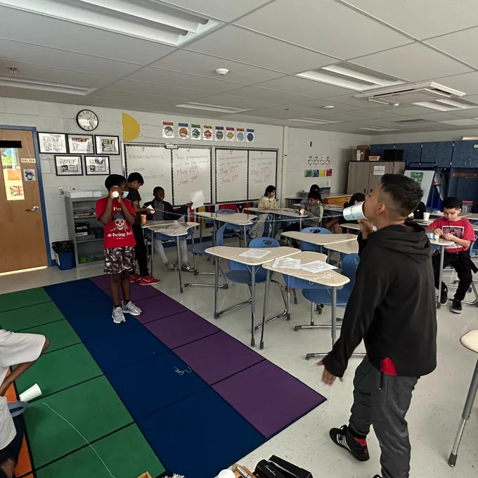 5th graders presenting the cup phone project to the class in Spanish.