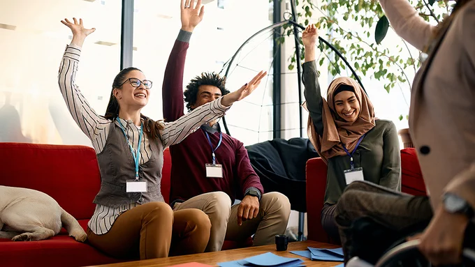 Image of smiling people with hands raised on Unsplash