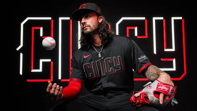 Jonathan India poses while tossing a baseball up in the air. India is wearing the Reds new City Connect uniforms. 