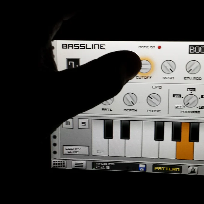Silhouette of a hand operating the Bassline synth of the Caustic app.