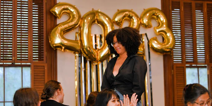 A student stands up amidst applause during the First Gen Senior Celebration. 