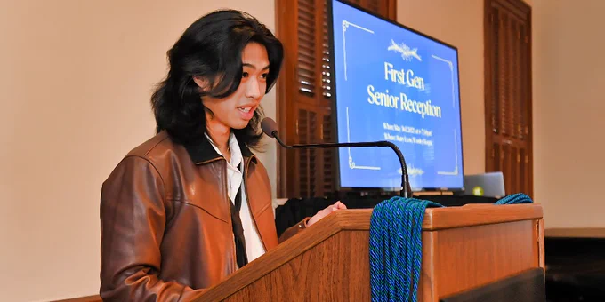 A student stands at a podium, giving a speech during the First Gen Senior Reception.