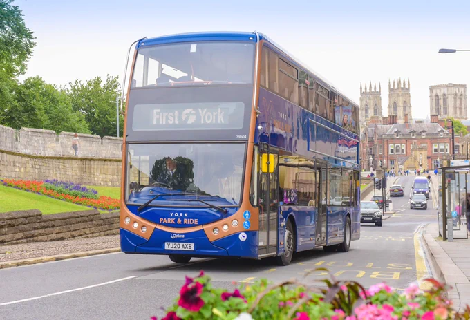 A double decker bus in York with York Minster in the background.