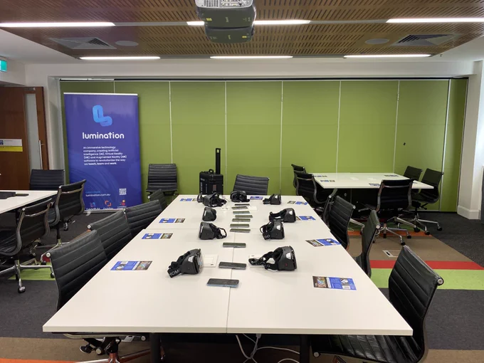 Table with VR and AR technology, flyers and Lumination pull-up banner in background 