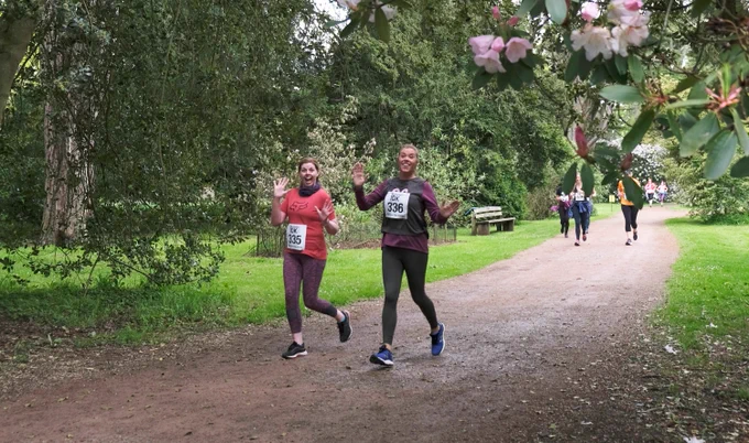 runners on track surrounded edged by grass and trees at Westonbirt Arboretum