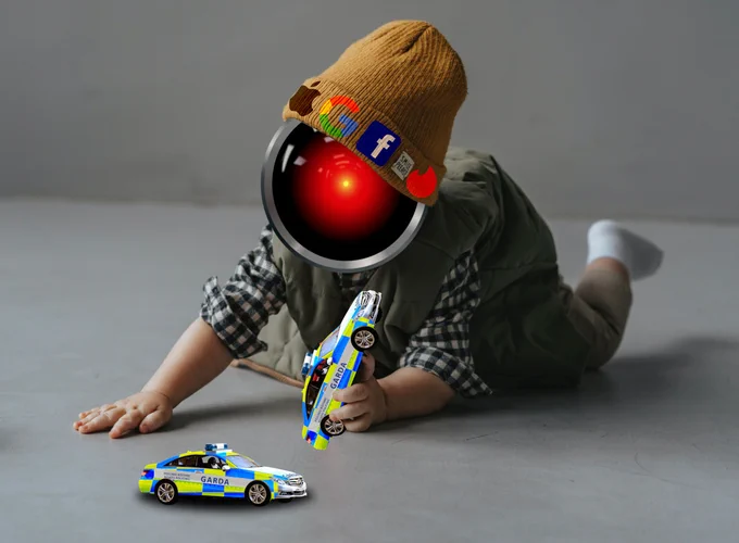 A toddler playing with toy cars. The cars are Irish police cars. The toddler's head has been replaced with the menacing, glowing red eye of HAL9000 from Stanley Kubrick's '2001: A Space Odyssey.' The toddler's knit cap is decorated with the logos for Apple, Google, Facebook and Tinder.



Image:
Cryteria (modified)
https://commons.wikimedia.org/wiki/File:HAL9000.svg

CC BY 3.0
https://creativecommons.org/licenses/by/3.0/deed.en

