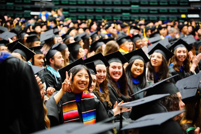 A group of students smile at the CSU Graduate School Commencement Ceremony.