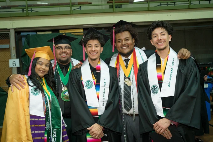 A group of five students in graduation regalia smile at the Spring 2023 CSU commencement Ceremony.