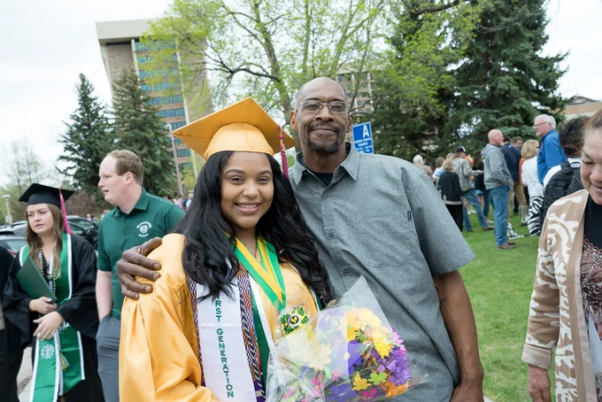 A student smiles with a relative at the Spring 2023 CSU commencement Ceremony. 
