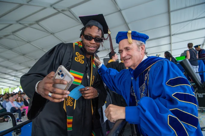 A new graduate takes a selfie with Kent State President Todd Diacon