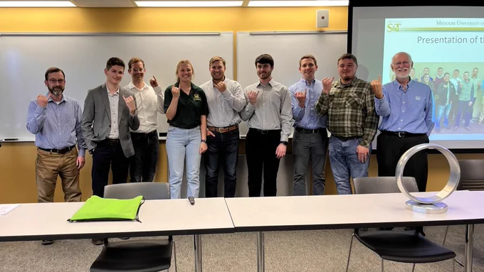Dr. Thomas and Dr. Carroll pose with the newest members of the Order of the Engineer as they all show off their steel ring.