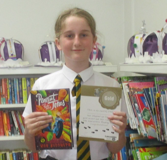 child holding a book and a certificate