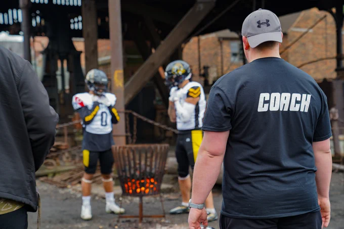 American Football players posing at the Museum with the Coach in shot 