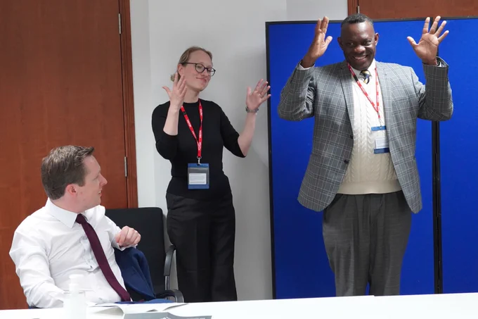  Minister Pursglove watching the BSL interpreter and a BSL Board member introduce himself to the group. 