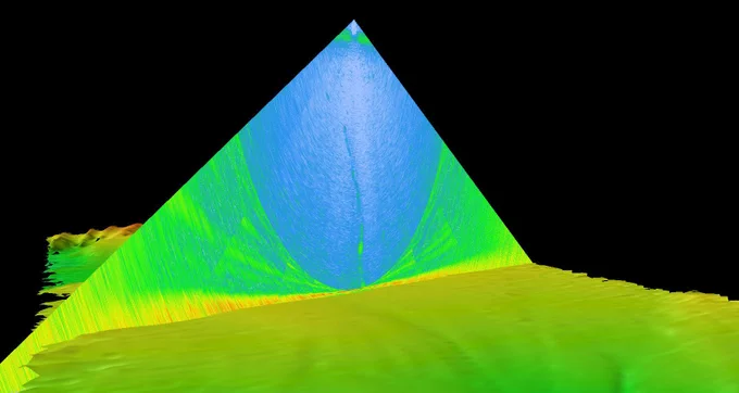 Water column data (shown as a triangular cross-section) overlaid on 3D-modeled multibeam bathymetry data. The gas seep detected near the Aleutian Trench is depicted as a green line extending from the middle of the water column data. 3D model produced by Amanda Bittinger, Sunset Hydrographics.