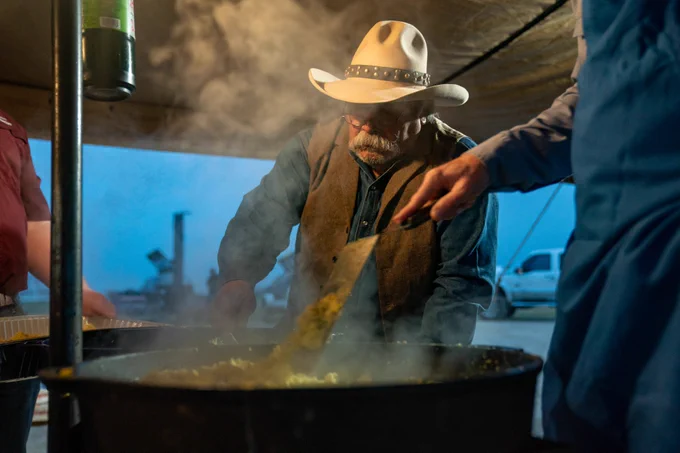 A gentleman stirring a pot at a traditional Texas barbecue
