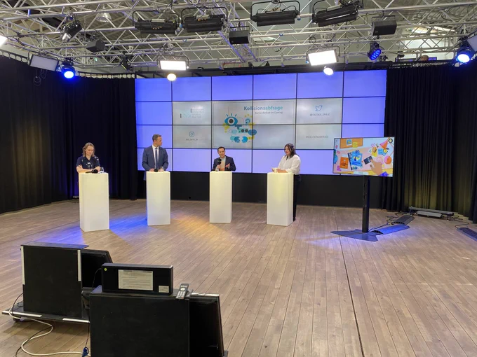 Panel „Inklusive Spieleentwicklung fördern“, im Hintergrund eine LED-Wand mit dem Logo der Konferenz, auf einer Screen rechts läuft das Spiel FINDING HANNAH.