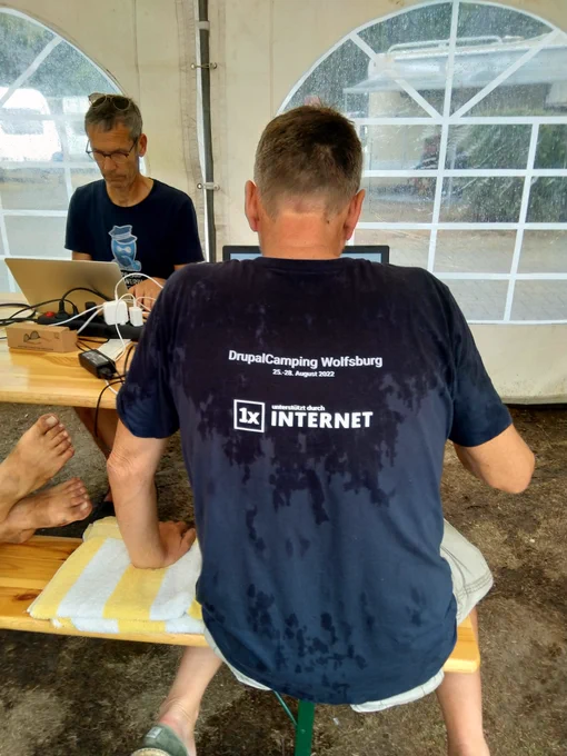 Olaf und Michael sprinten beim DrupalCamping 2022, trotz strömendem Regen.