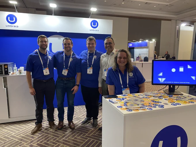 The Umbraco team is posing at their booth at CMSWire CONNECT.