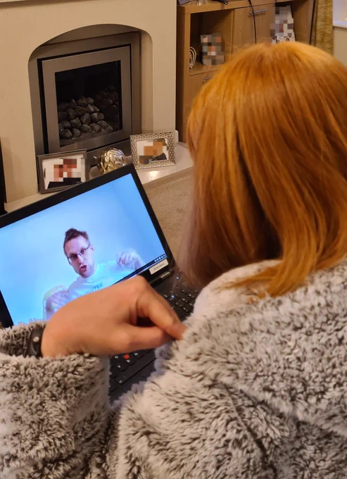 Me pointing at shoulders part way through the Laughtercise session from health and wellbeing week. Laptop on my lap.