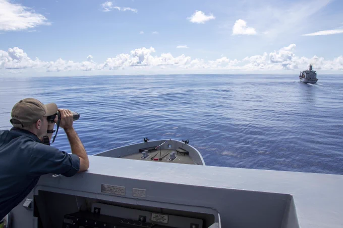 Lt. j.g. Christopher Flor uses a laser rangefinder aboard USS Anchorage (LPD 23) to determine the distance between the it and USNS Guadalupe (T-AO 200) before a replenishment in the Philippine Sea. 📸 Mass Communication Specialist 1st Class Tom Tonthat