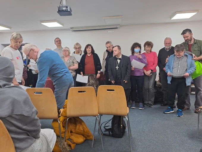 A photo of people the choir singing with people enjoying the music.