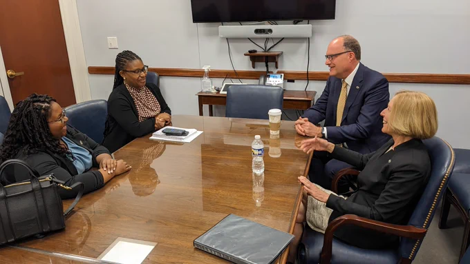 Rachel McKinley, Nadia Laniyan, Kevin Gardner and Ann Stock sit at a conference table during their meeting at U.S. Sen. Cory Booker's office.