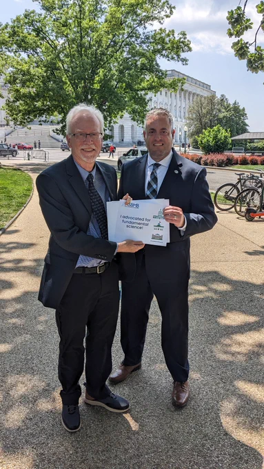 Ronald Wek and Rick Page hold their "I advocated for fundamental science!" sign for a photo in front of the U.S. Capitol during ASBMB's Hill Day.