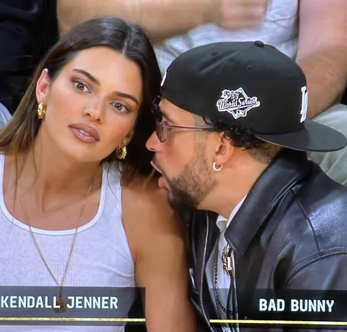 Bad Bunny talking intensely to Kendall Jenner about getting a Library card at a Lakers playoff game.