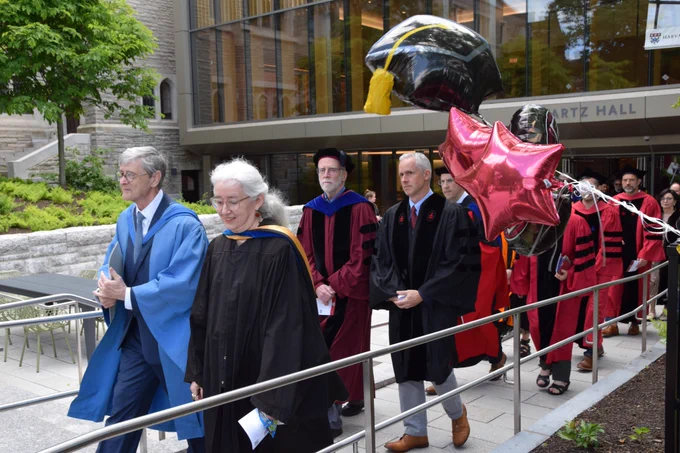 HDS graduates exit Swartz Hall led by Dean Hempton.