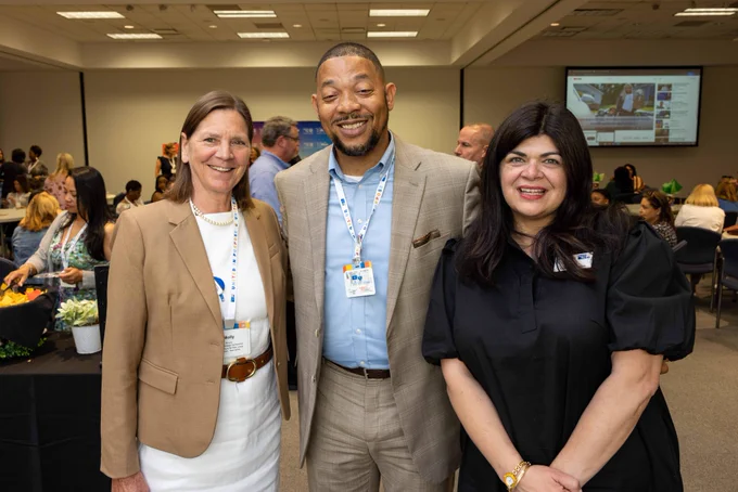 Franklyn Baker stands in the middle, with Molly Rennie on the left and Cary Dawson on the right. Dressed in business casual attire, all three smile at the camera.