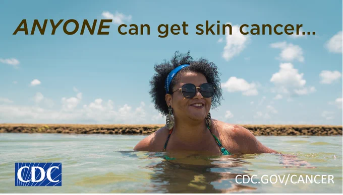 Woman with a darker skin tone in the water at a beach. Text: Anyone can get skin cancer...