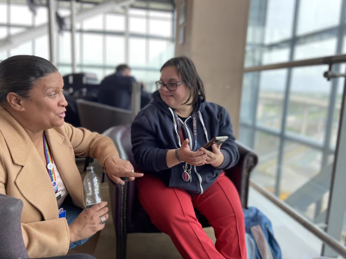 A HEX colleague chatting to a PiP student whilst sat watching planes land at terminal 5