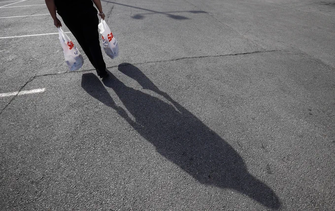 A woman in Chicago carries her groceries home in this 2014 file photo. On March 1, 2023, 32 states, the District of Columbia and U.S. territories ended a temporary COVID-era increase in the federal Supplemental Nutrition Assistance Program benefits. Eighteen states previously ended the additional SNAP payments that Congress provided to states in March 2020 to help low-income individuals and families deal with the financial hardships of the pandemic. (OSV News photo/Jim Young, Reuters)