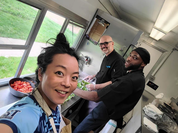 Fran and chefs in a kitchen taking a selfie