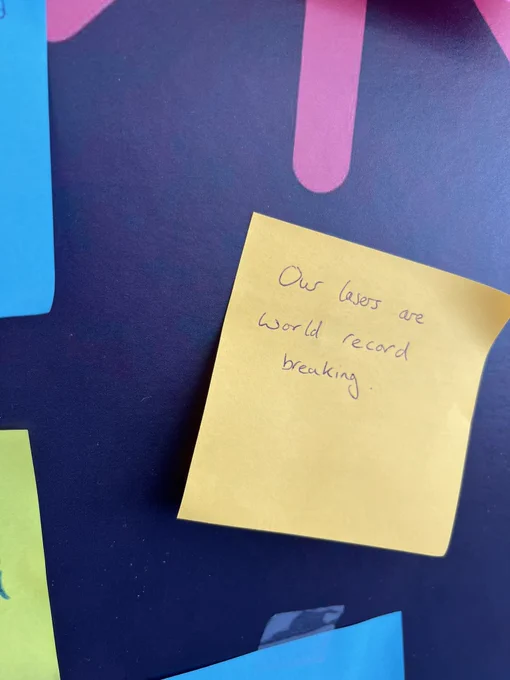 Sticky note saying “our lasers are world record breaking”