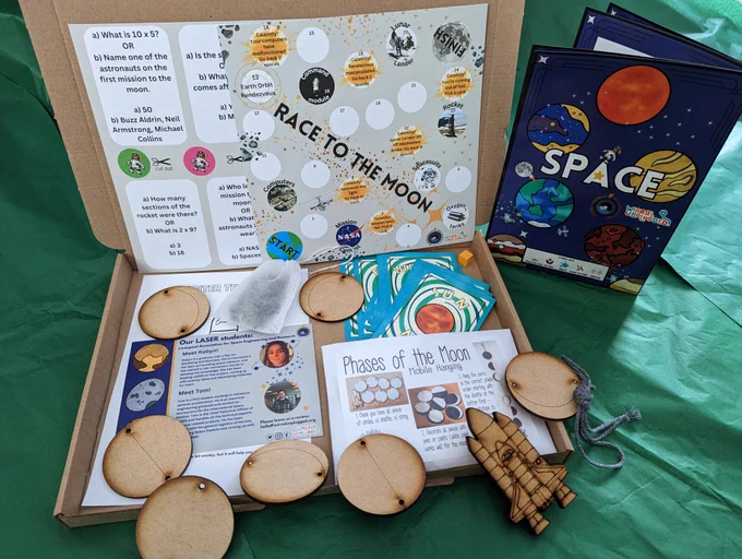 Picture of our space box, with planets, rockets, snap cards, game boards and a booklet