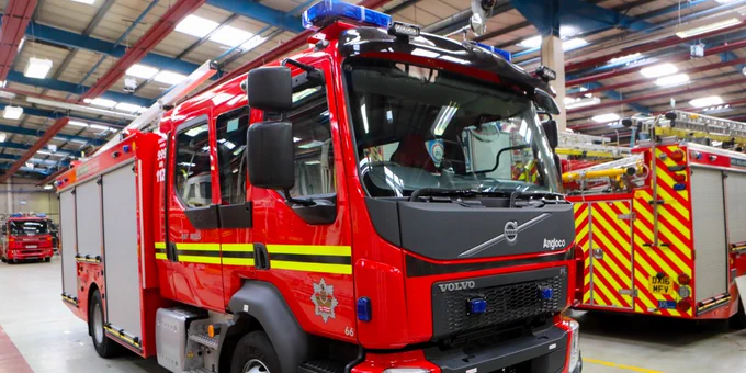 A fire engine parked in a fire station bay.
