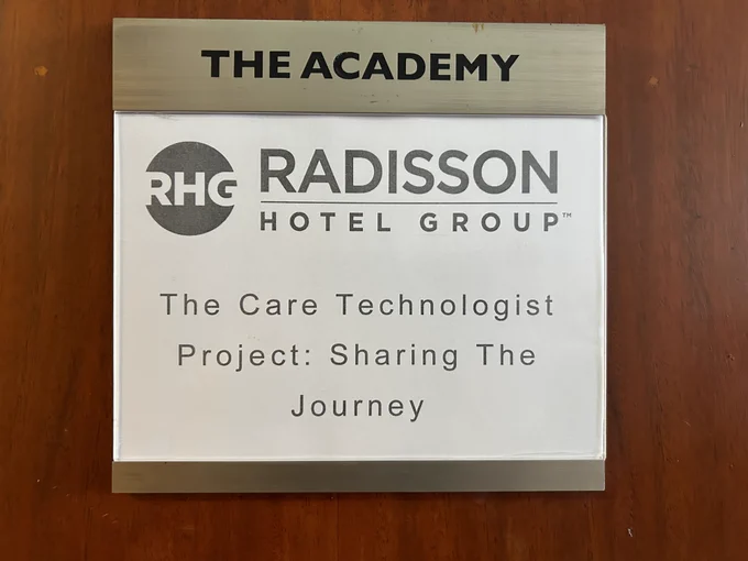 Door sign with breakout session title " The Care Technologist Project: Sharing the Journey" posted on it. 
